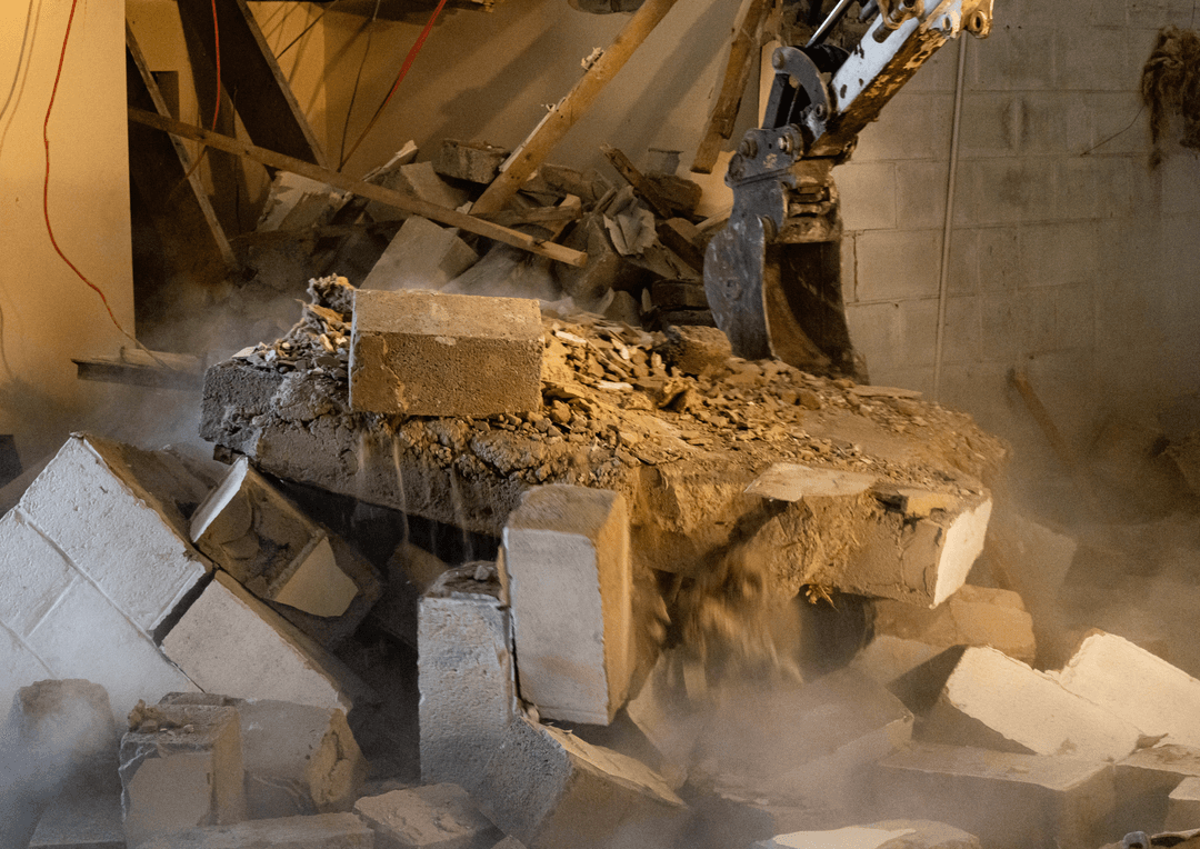 a photo of a house demolition being done by an excavator